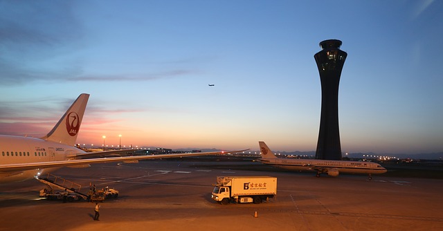 Dve lietadlá a nákladné auto na letisku v noci.jpg